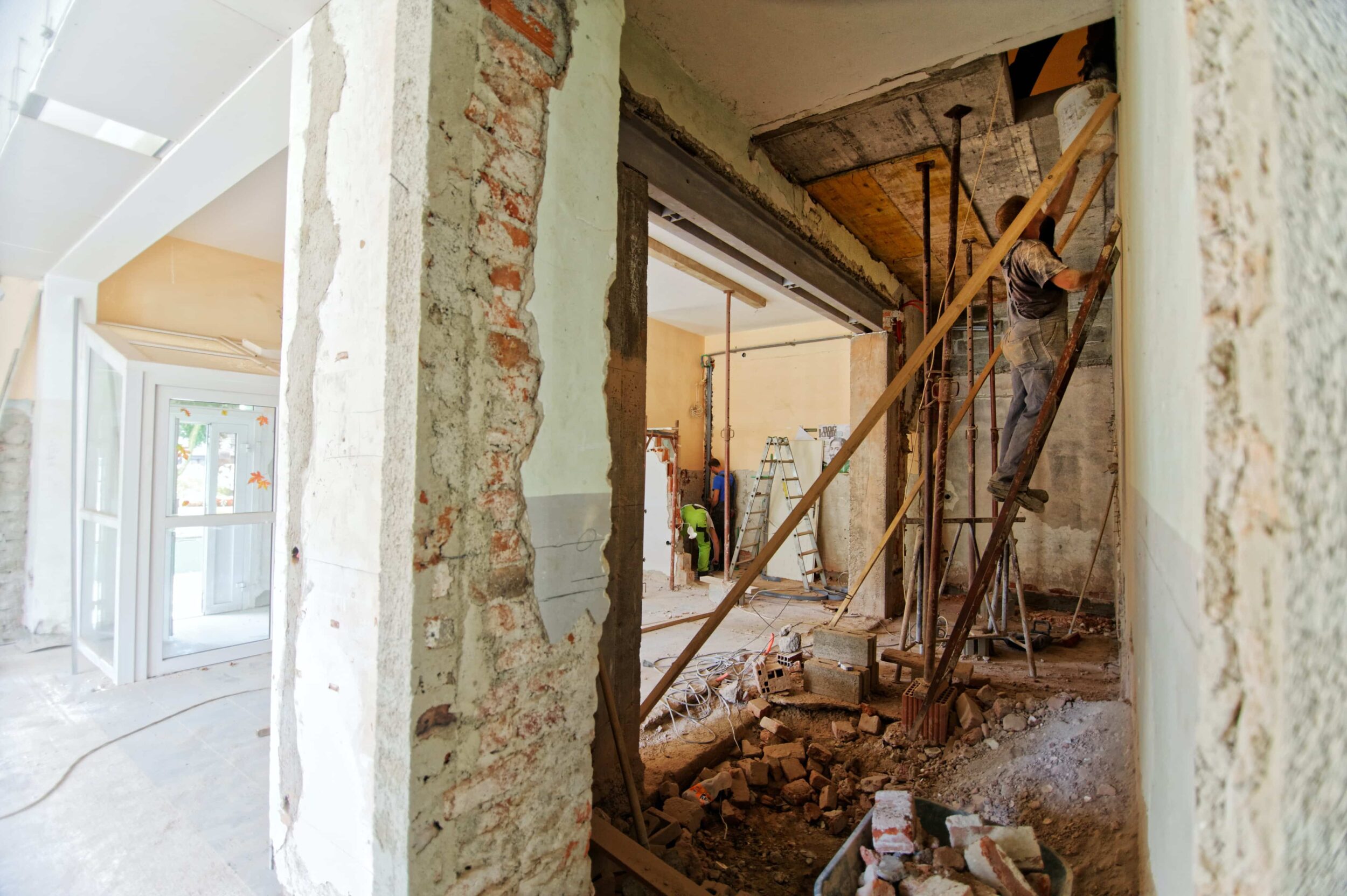 A home being renovated with workers inside a partly demolished house