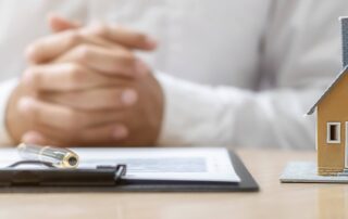close up of mortgage broker hands paperwork and house to explain hard money vs soft money loans