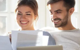 couple reviews loan application on couch