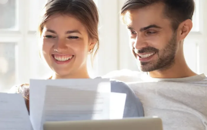couple reviews loan application on couch