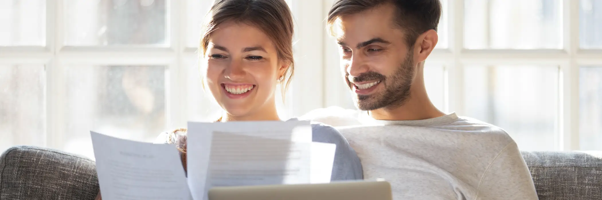couple reviews loan application on couch